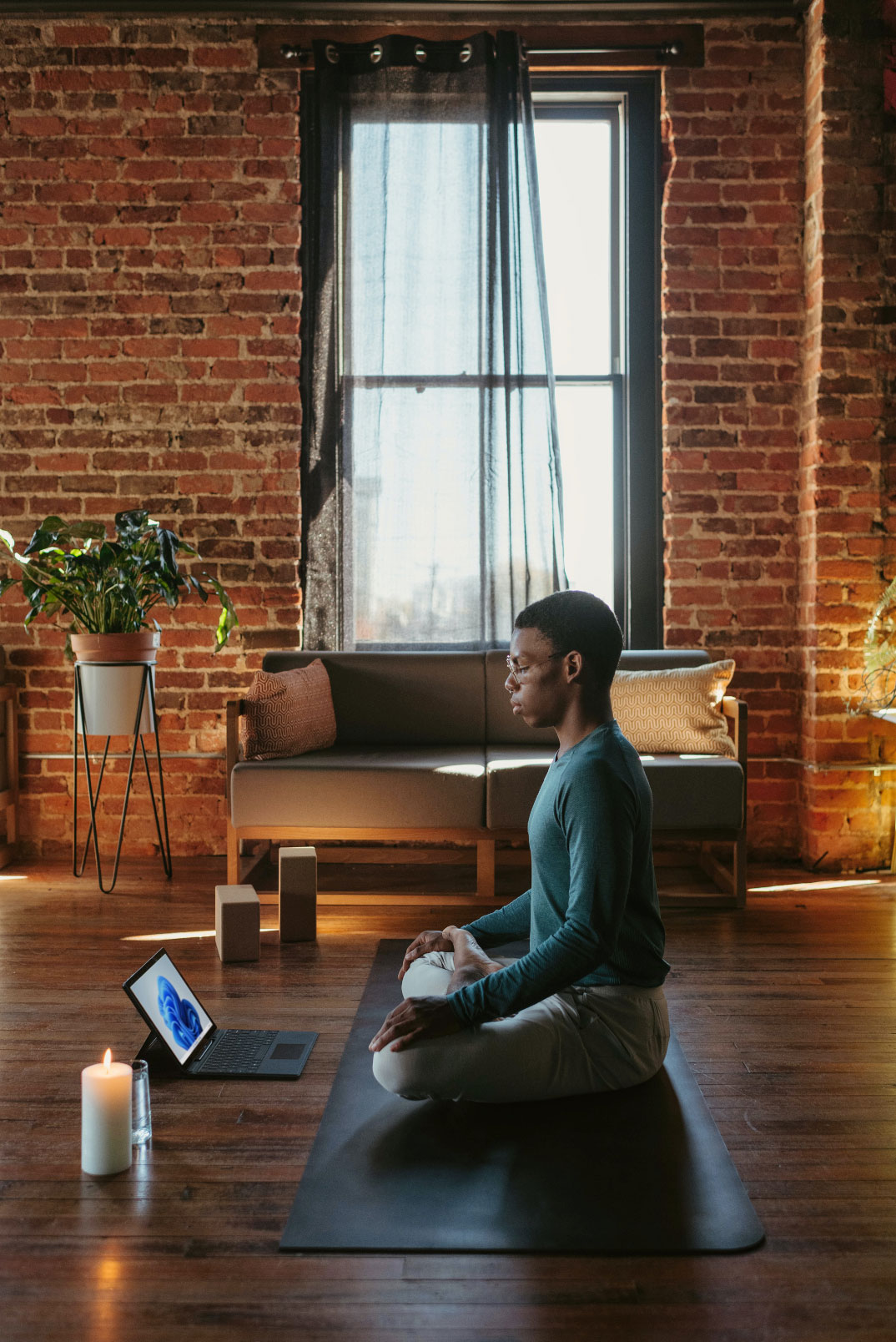 person on a yoga mat with a computer