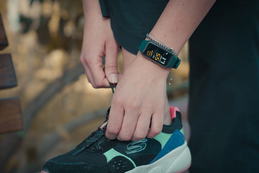 person tying their shoe with a smartwatch