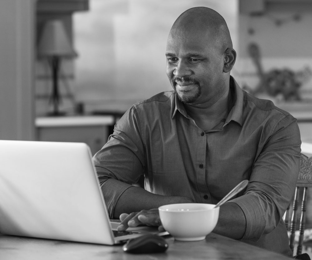 man at his computer using telehealth